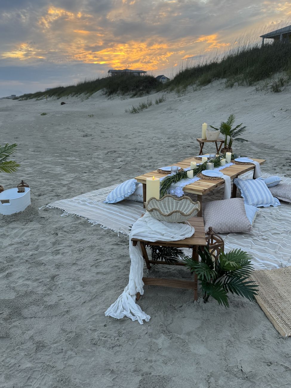 Styled beach dinner table at golden hour with dune backdrop